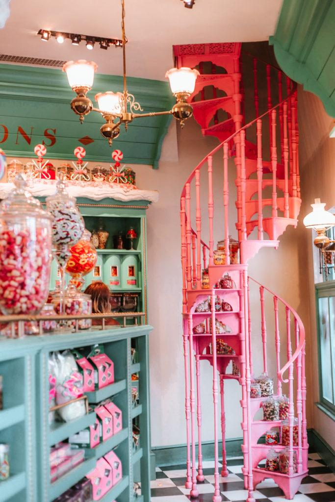 Pink spiral staircase and shelves of pink and teal pastel candies